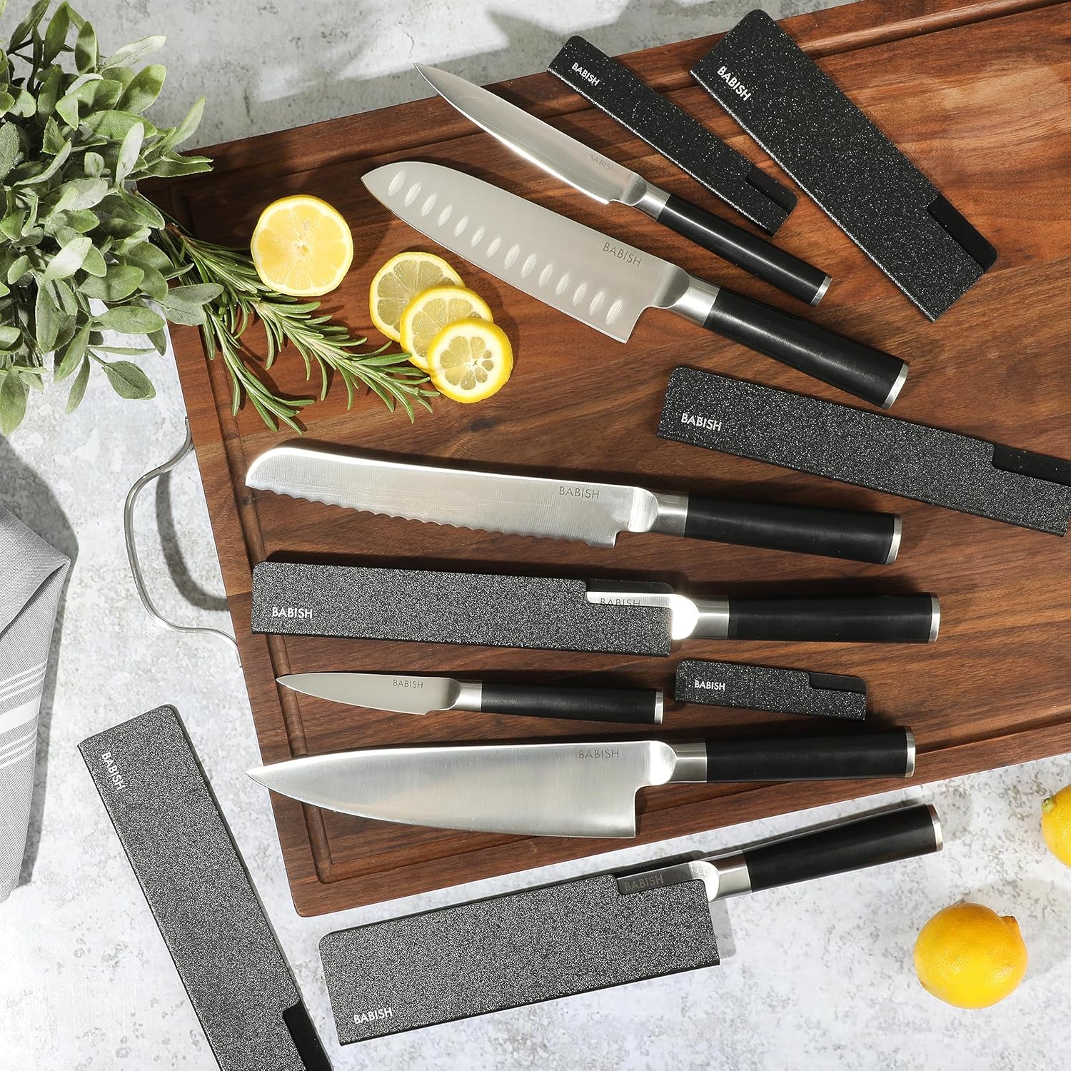 14-piece kitchen knife set with high-carbon German steel blades and black protective sheaths displayed in row — view 2