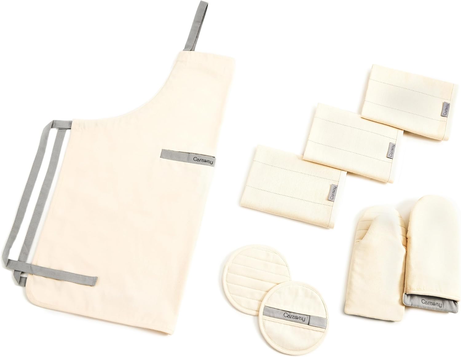 Four-piece organic cotton kitchen linen set including natural linen apron, matching pot holders, oven mitts, and tea towels โ front