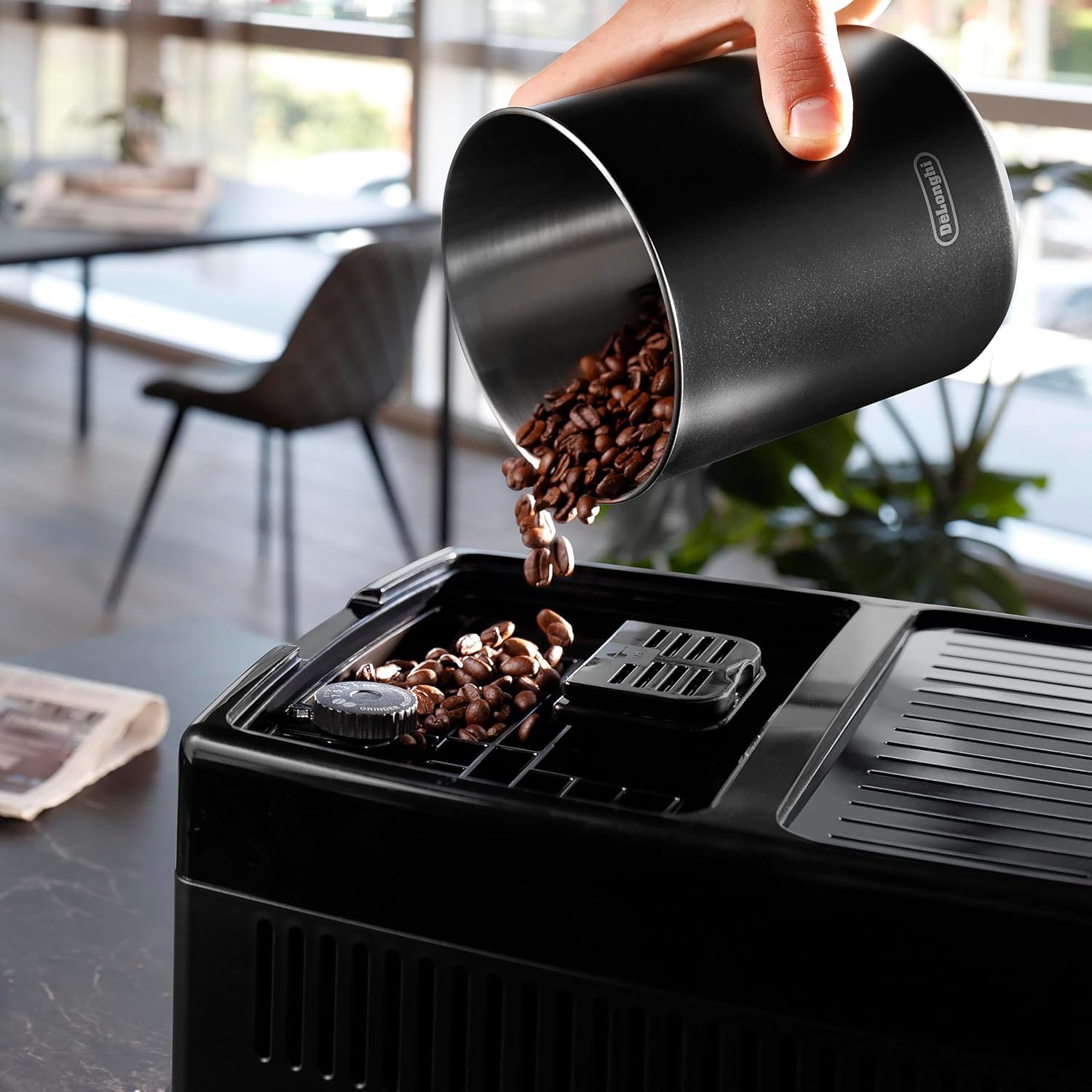 Stainless steel De'Longhi Dinamica Plus fully automatic espresso machine with integrated grinder and milk frother on countertop — view 2