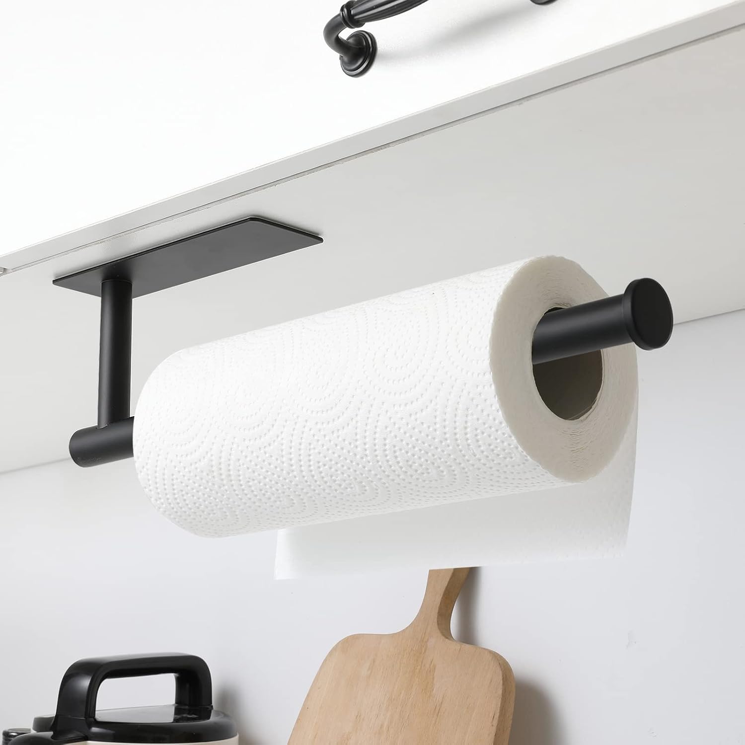 Black plastic adhesive under-cabinet paper towel holder mounted on kitchen cabinet โ view 1