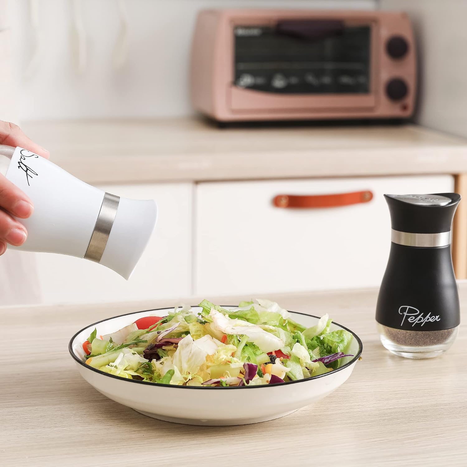 Ceramic salt and pepper shaker set in white, handheld design for kitchen table use โ view 3